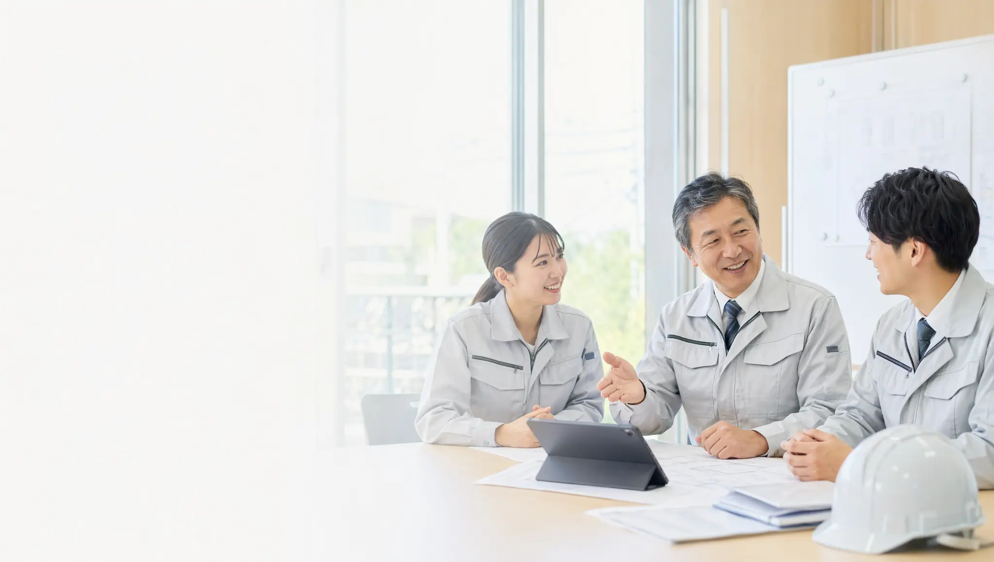 建設会社の経営者・管理者・若手社員が自然に会話している様子